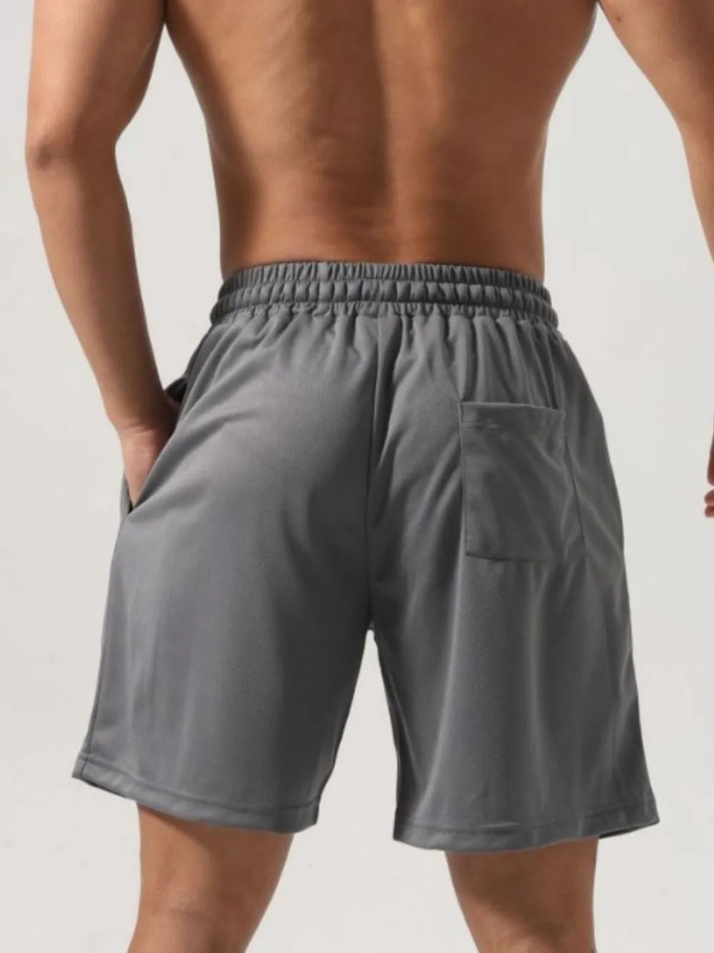 Gray mesh gym shorts with elastic waist and back pocket.