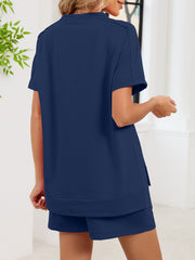 Navy blue relaxed two-piece set with short sleeves and pockets, featuring a high-low hem.