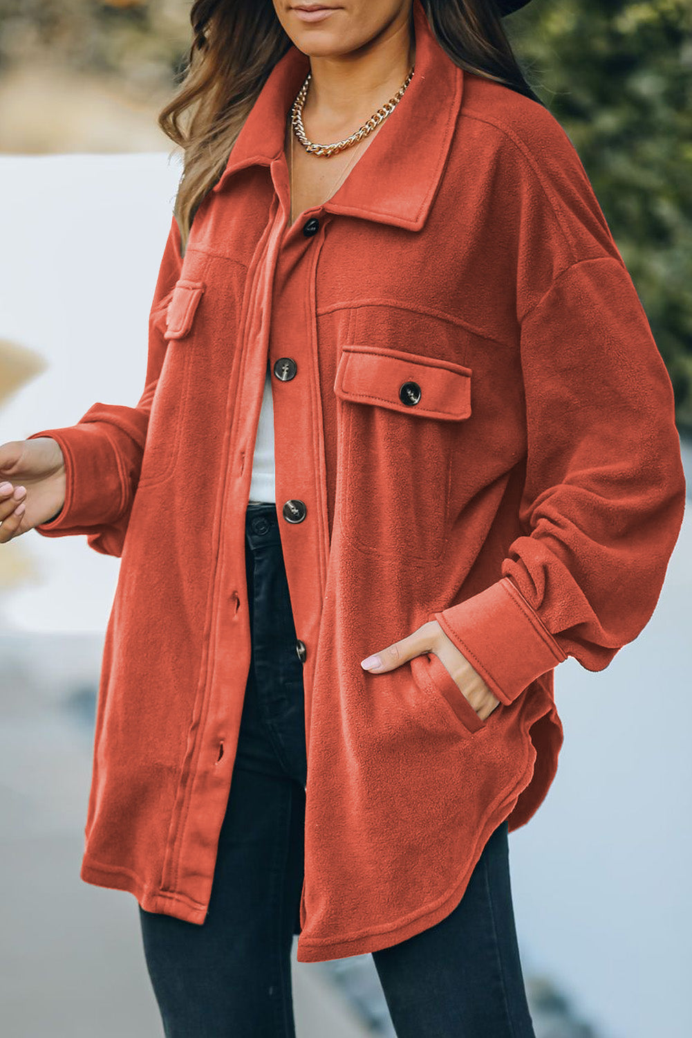 Fleece shirt jacket in orange with patch pockets and button front.