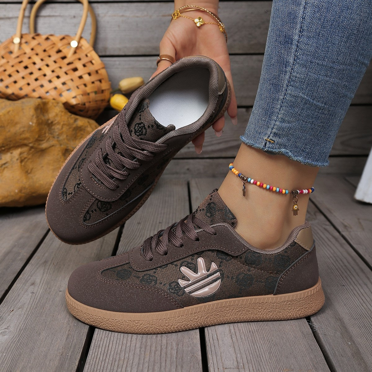 Brown round toe lace up sneakers with all over pattern and logo detail.