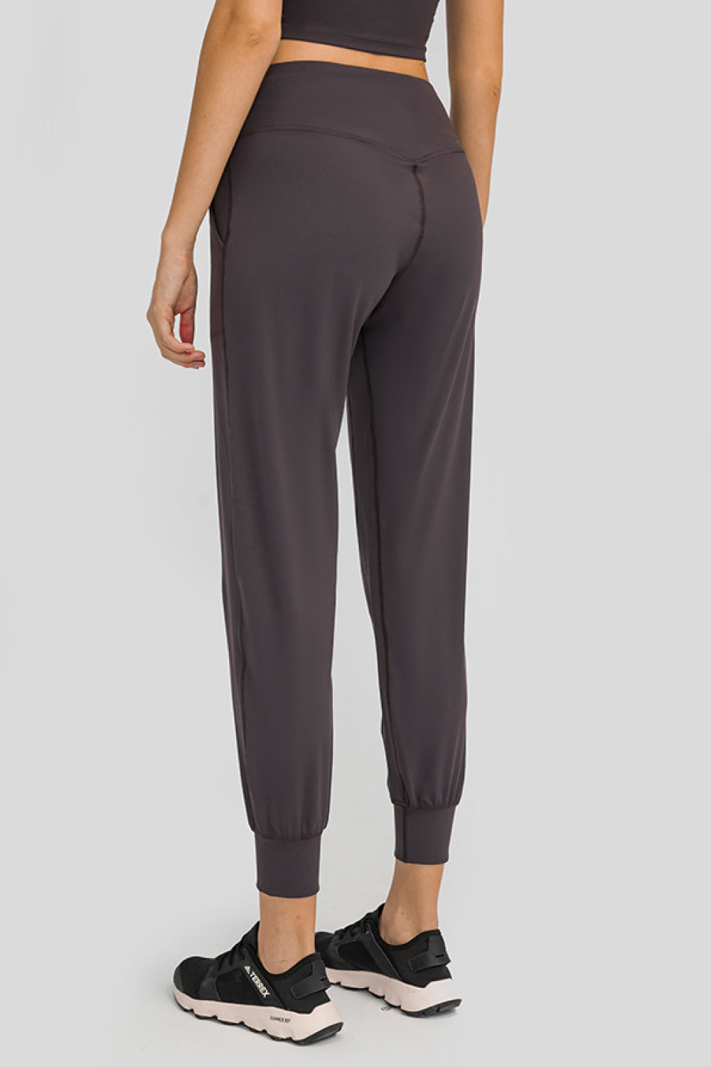 Dark gray jogger fit performance trousers with pockets and cuffed ankles.