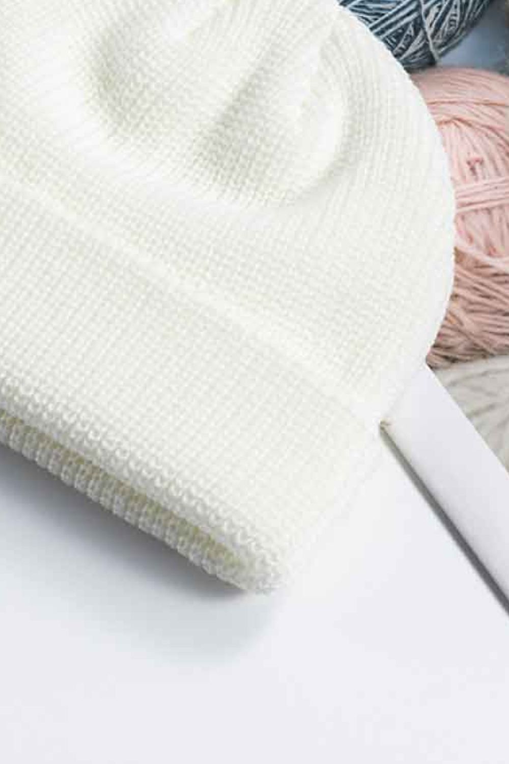 White ribbed knit beanie with a turn-up cuff, acrylic material