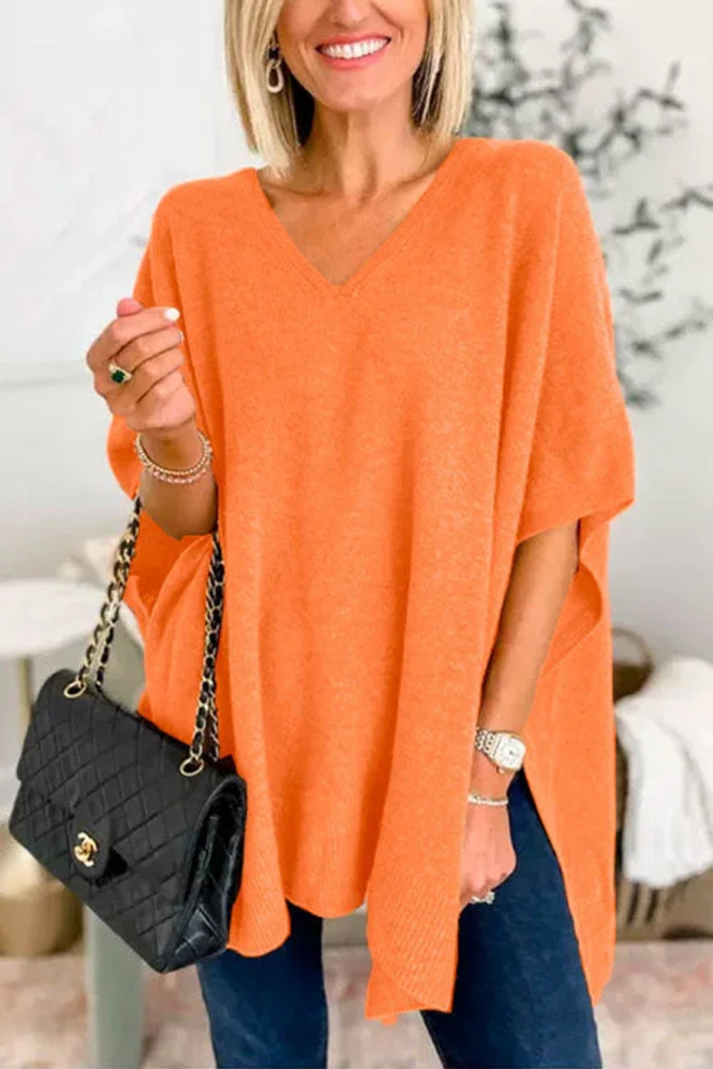 Relaxed V-neck knit poncho top in Pumpkin with short sleeves and side slits.