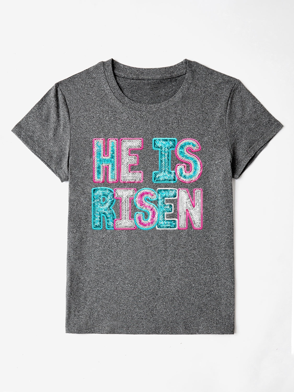 Gray crewneck t-shirt with sequin-textured "He Is Risen" graphic in pink and aqua.