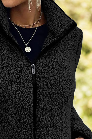 Black teddy fleece zip-up jacket with a stand collar and silver zipper detail.