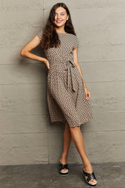 Camel geometric print midi dress with tie waist and short sleeves.