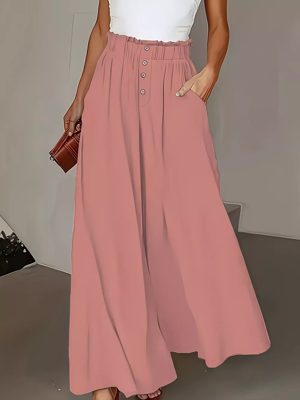 Pale blush wide-leg trousers with paperbag waist and button detail.