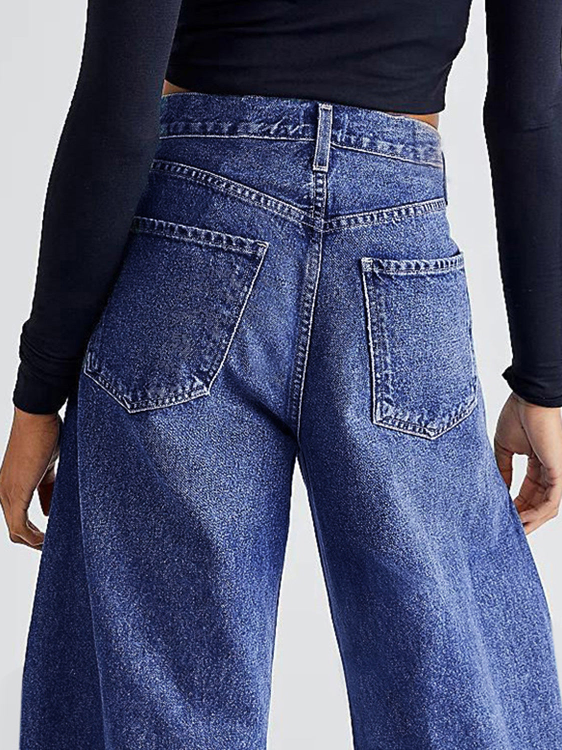 Medium wash denim palazzo jeans with frayed hem detail, shown from the back.