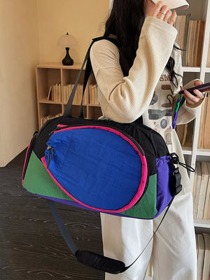 Vibrant nylon sport duffle bag with bold color block design and adjustable strap.