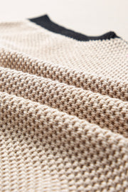 Beige knit top with black trim detail and cap sleeves.