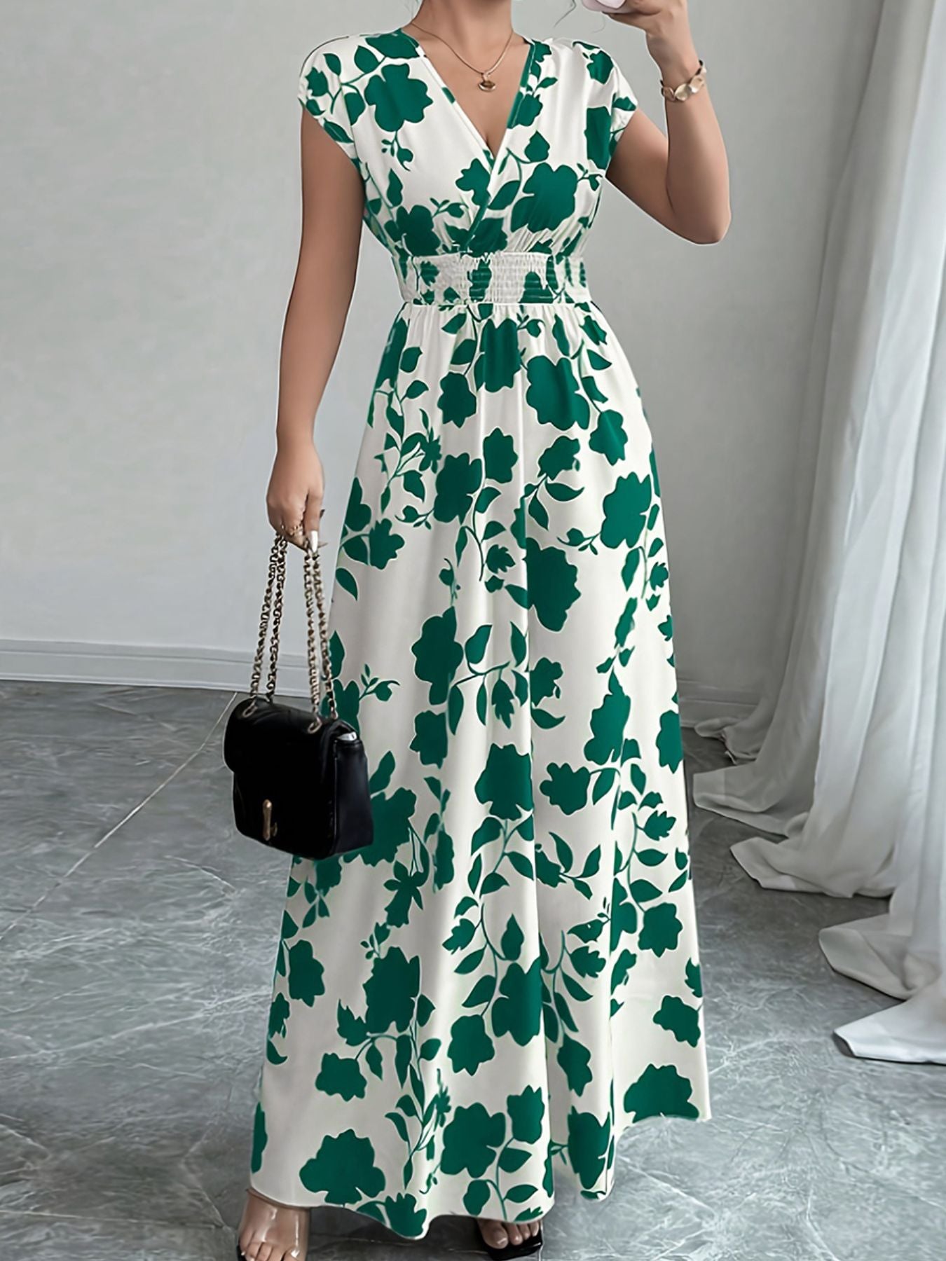 Floral maxi dress with surplice neckline, cap sleeves, and smocked waist in dark green and white.