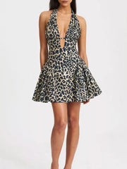 Leopard print halter neck mini dress with plunging neckline and flared skirt.