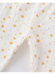 Kids' cotton pajamas in blush pink with a gold star print, showing inseam detail.