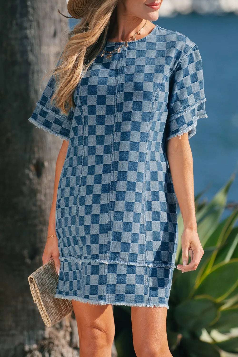 Denim mini dress with checkered pattern, frayed hems, and short sleeves.
