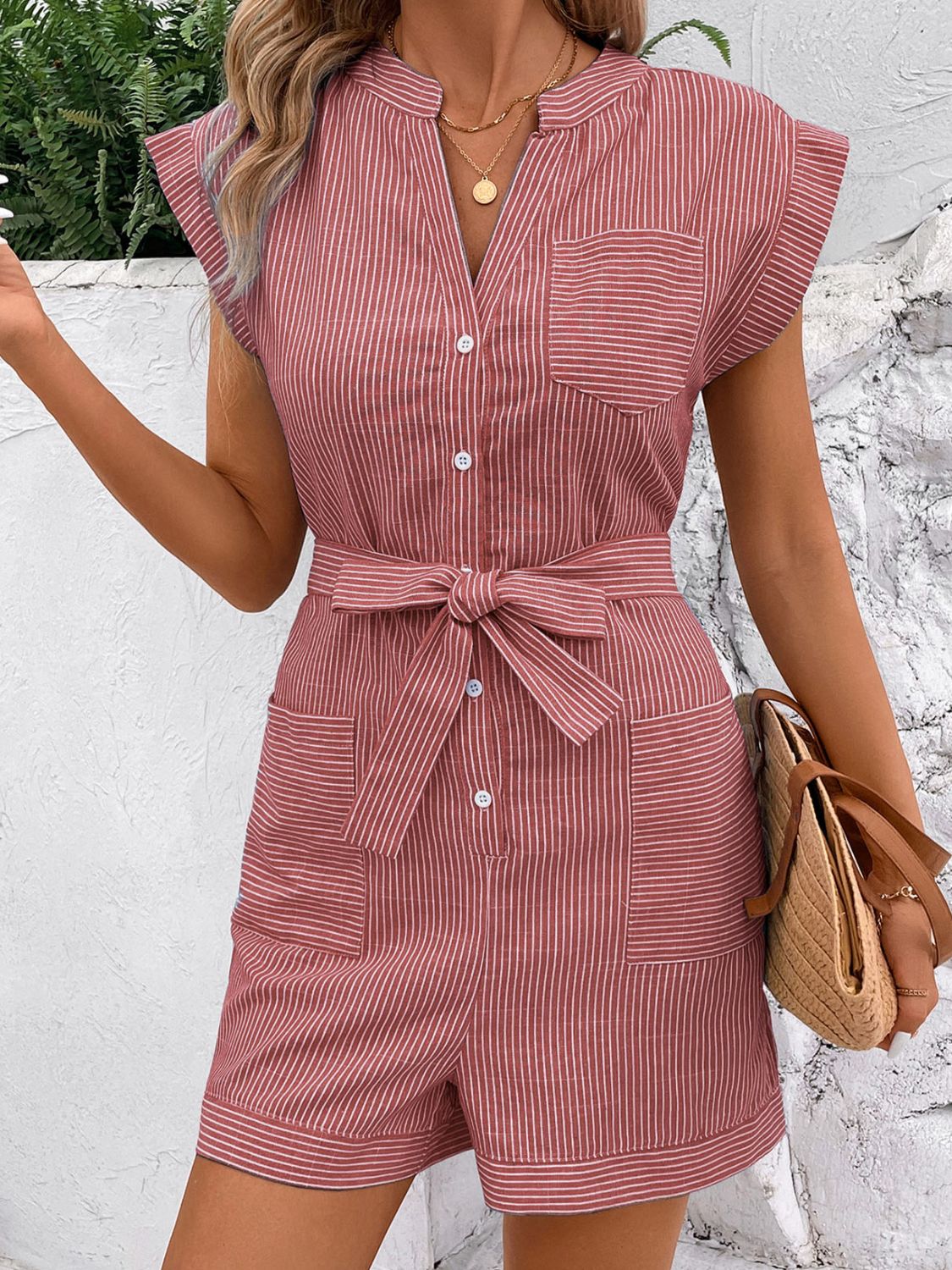 Dusty pink striped shirtdress romper with button front, tie waist, and pockets.
