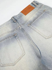Men's light wash vintage denim jeans with wide leg and brown leather back patch.