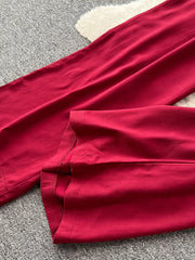 Wine red wide-leg jumpsuit detail showing hem and stitching.
