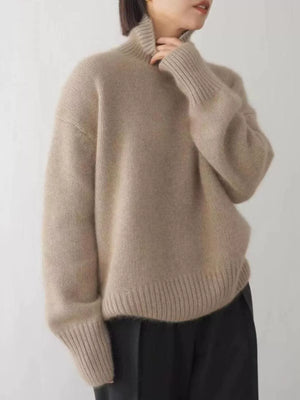 Beige acrylic turtleneck sweater with dropped shoulders and ribbed cuffs and hem.