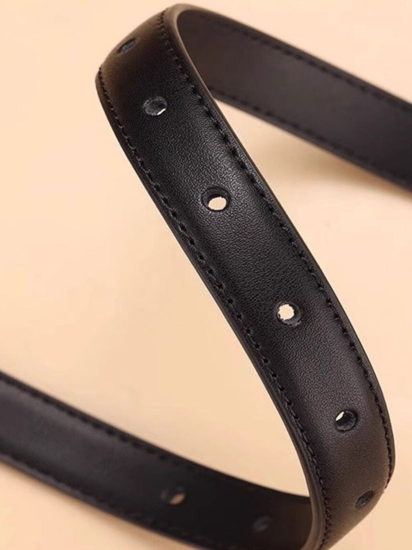 Black cowhide leather belt with silver buckle detail and multiple holes.