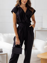 Black draped wrap-front wide-leg jumpsuit with cap sleeves and a tie waist.