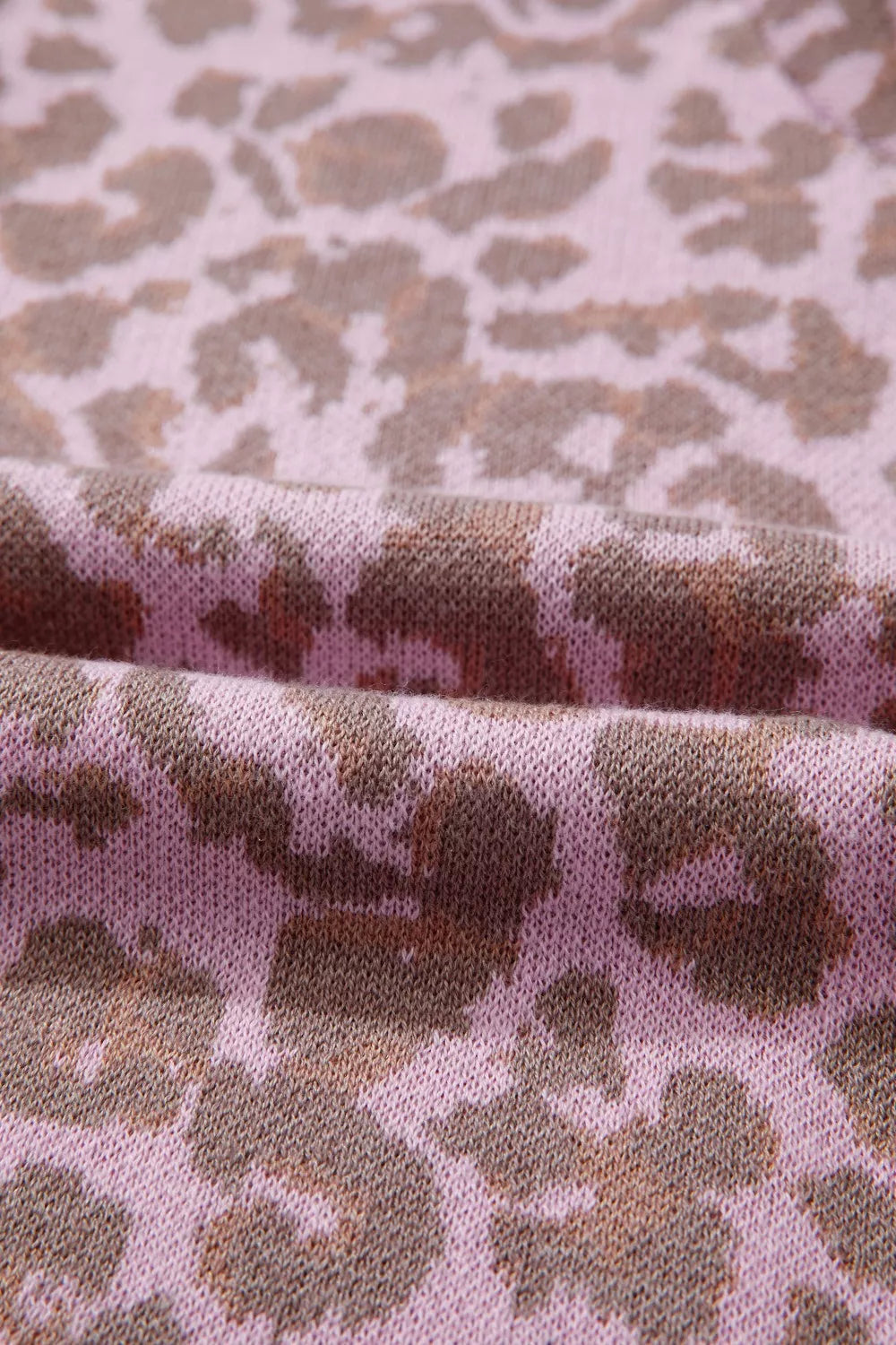 Knit fabric with a pink and brown leopard print pattern.