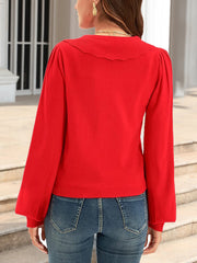 Red knit cardigan with scalloped collar and puff sleeves.