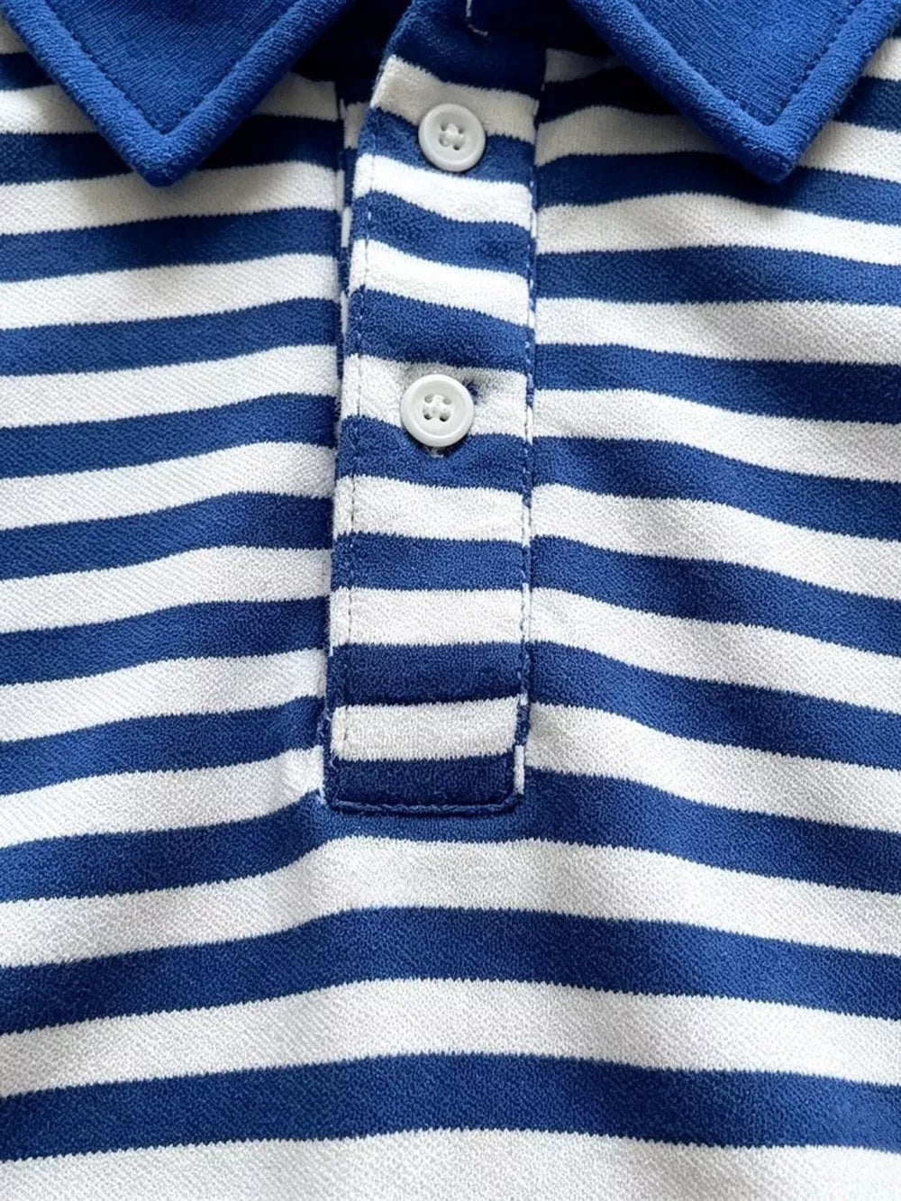 Blue and white striped baby polo shirt with two white buttons and a blue collar.