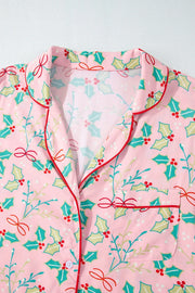 Blush pink pajama set with holly print, red piping, and bow details.