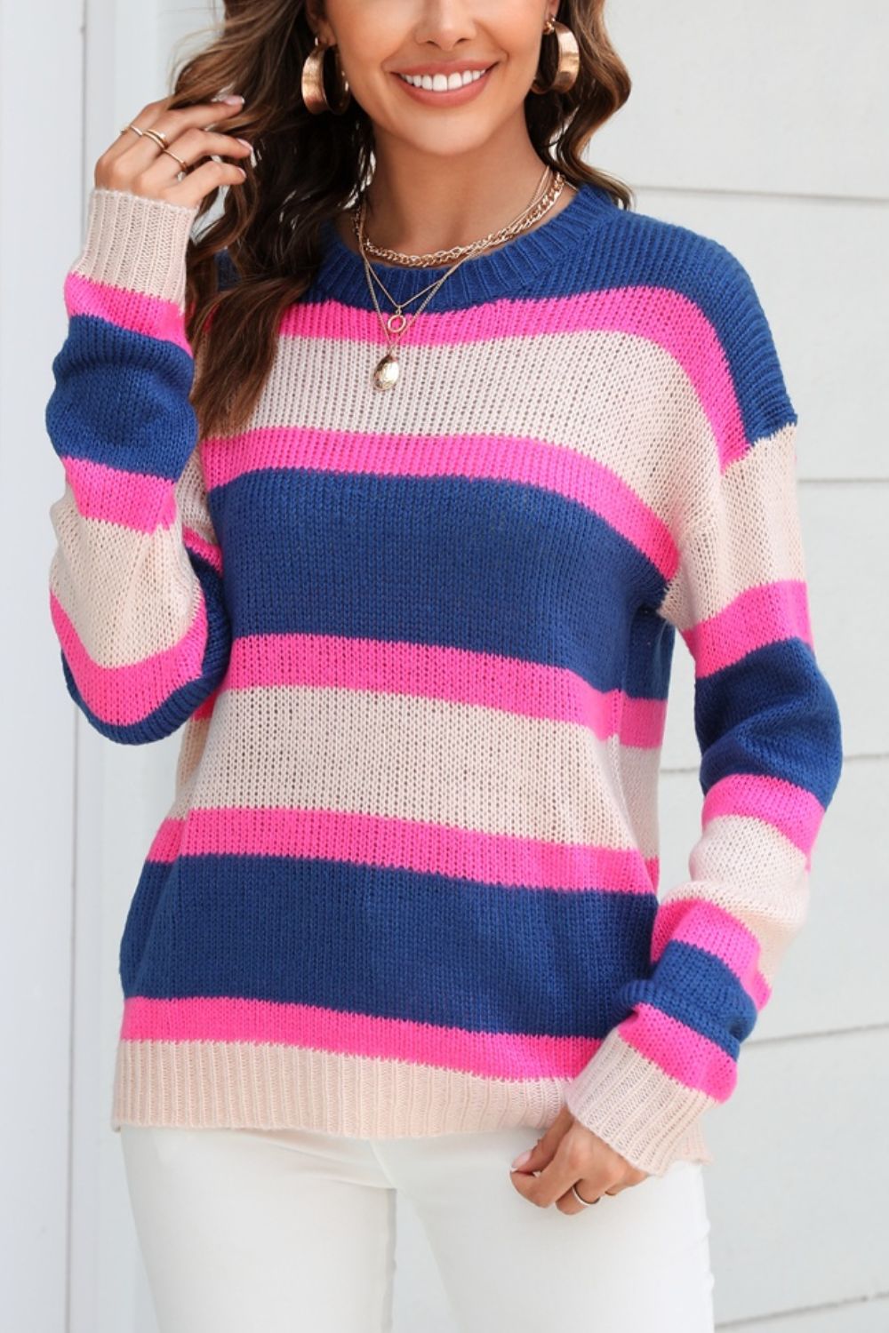 Bold stripe crewneck knit sweater in acrylic with blue, pink, and beige horizontal stripes.