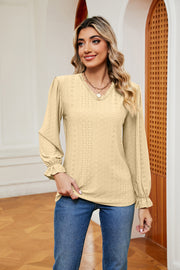 Pastel yellow perforated blouse with V-neck and ruffle cuffs
