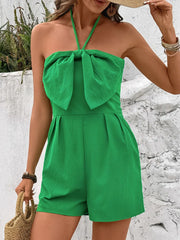 Green halterneck romper with large bow front and smocked back detail.
