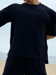 Black oversized cotton tee with drop shoulder and crew neck.