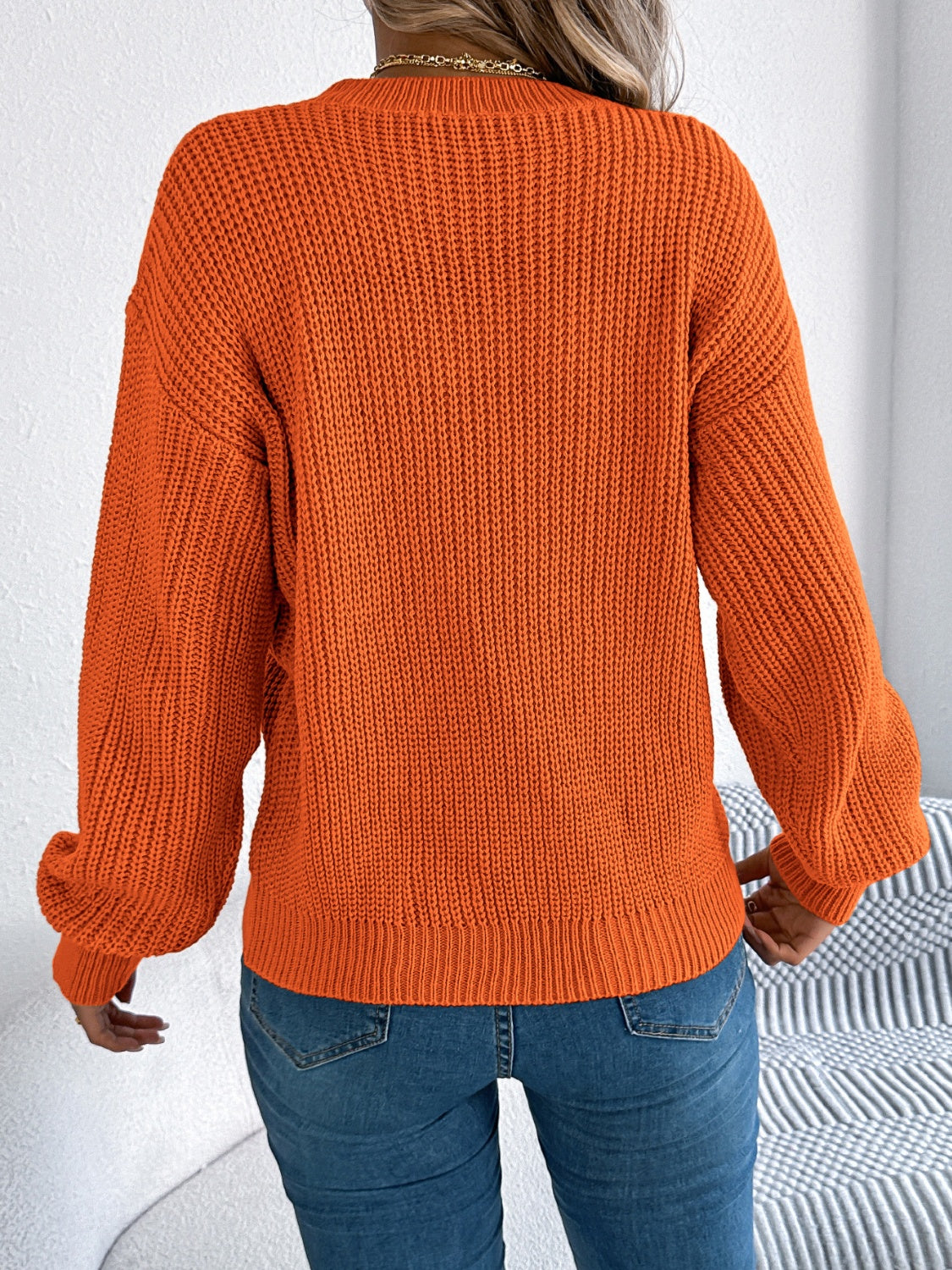 Orange acrylic chevron knit sweater with balloon sleeves and ribbed trim.