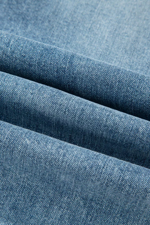 Distressed denim flare jeans in a light blue wash, showing fabric texture.