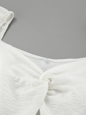 White off-shoulder midi dress with twisted detail and textured fabric