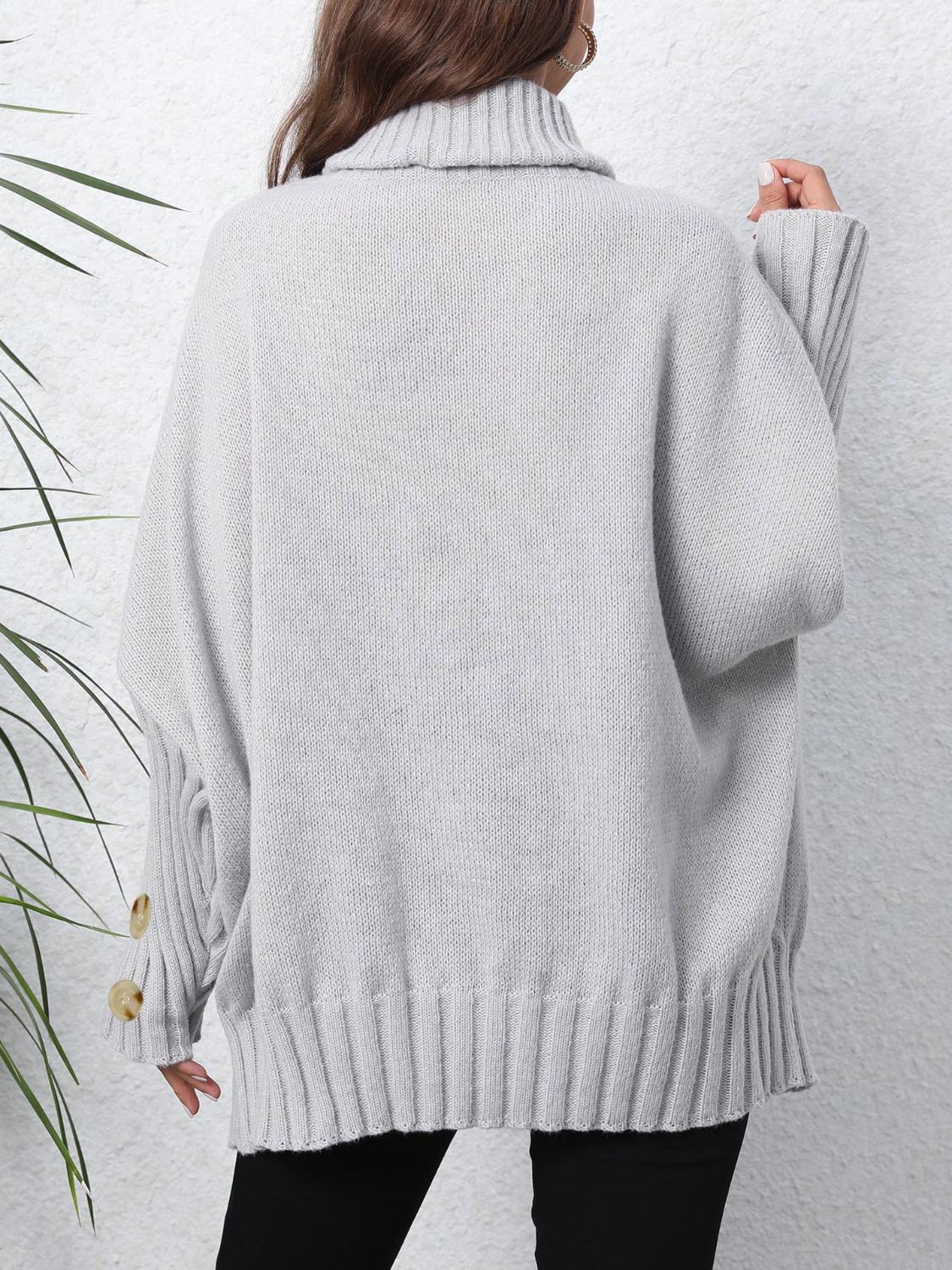 Light gray turtleneck sweater with button cuffs and ribbed hem.