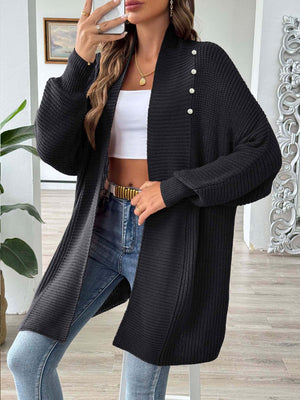 Black ribbed knit cardigan with pearl buttons and a draped neckline.