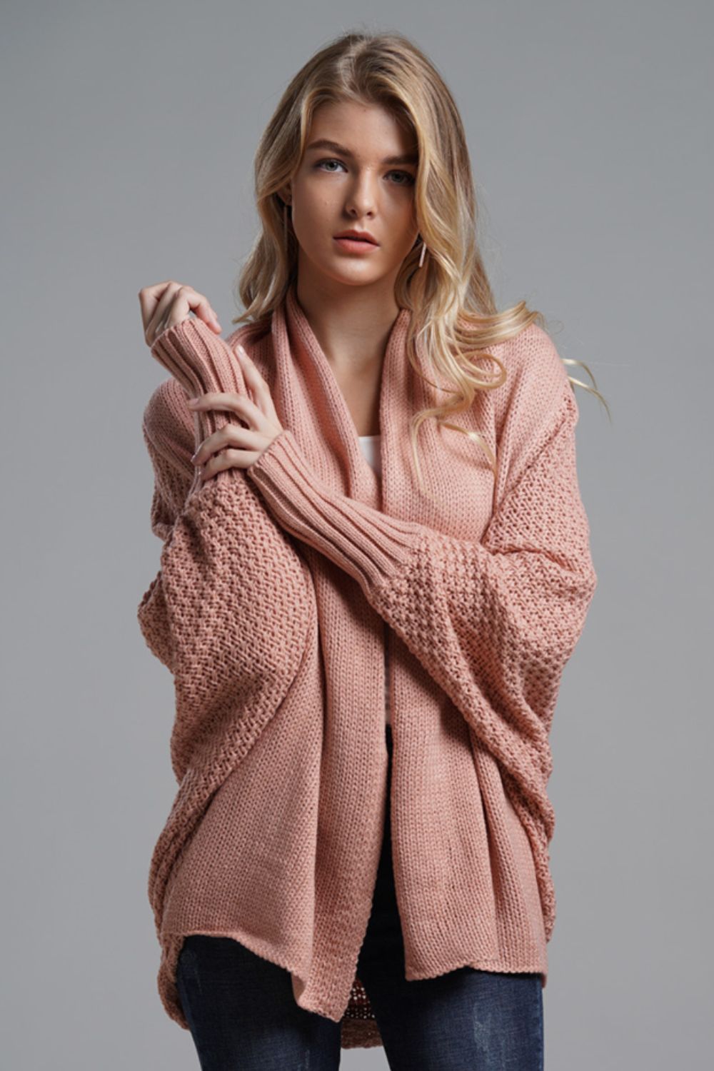 Pink acrylic batwing cardigan with drape front and textured sleeves.