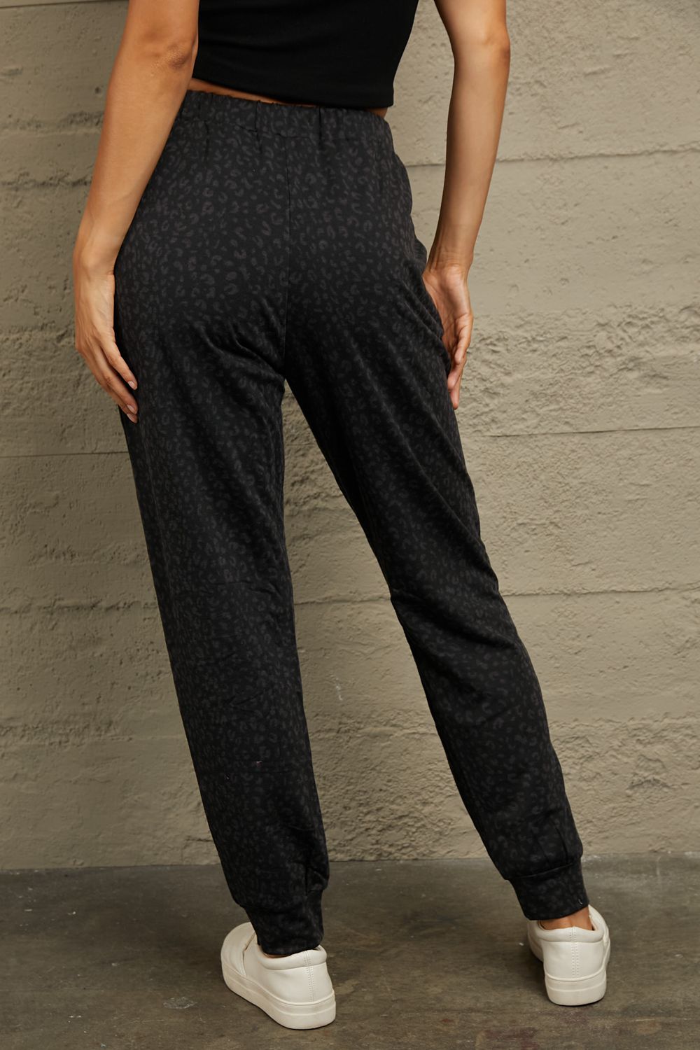 Black leopard print relaxed-fit drawstring trousers with cuffed ankles.
