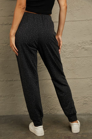 Black leopard print relaxed-fit drawstring trousers with cuffed ankles.