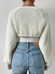 White cropped knit bolero shrug with balloon sleeves and ribbed texture.