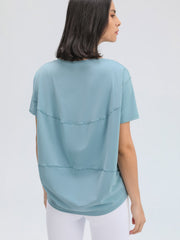 Dusty blue relaxed fit performance tee with horizontal seam details on back.