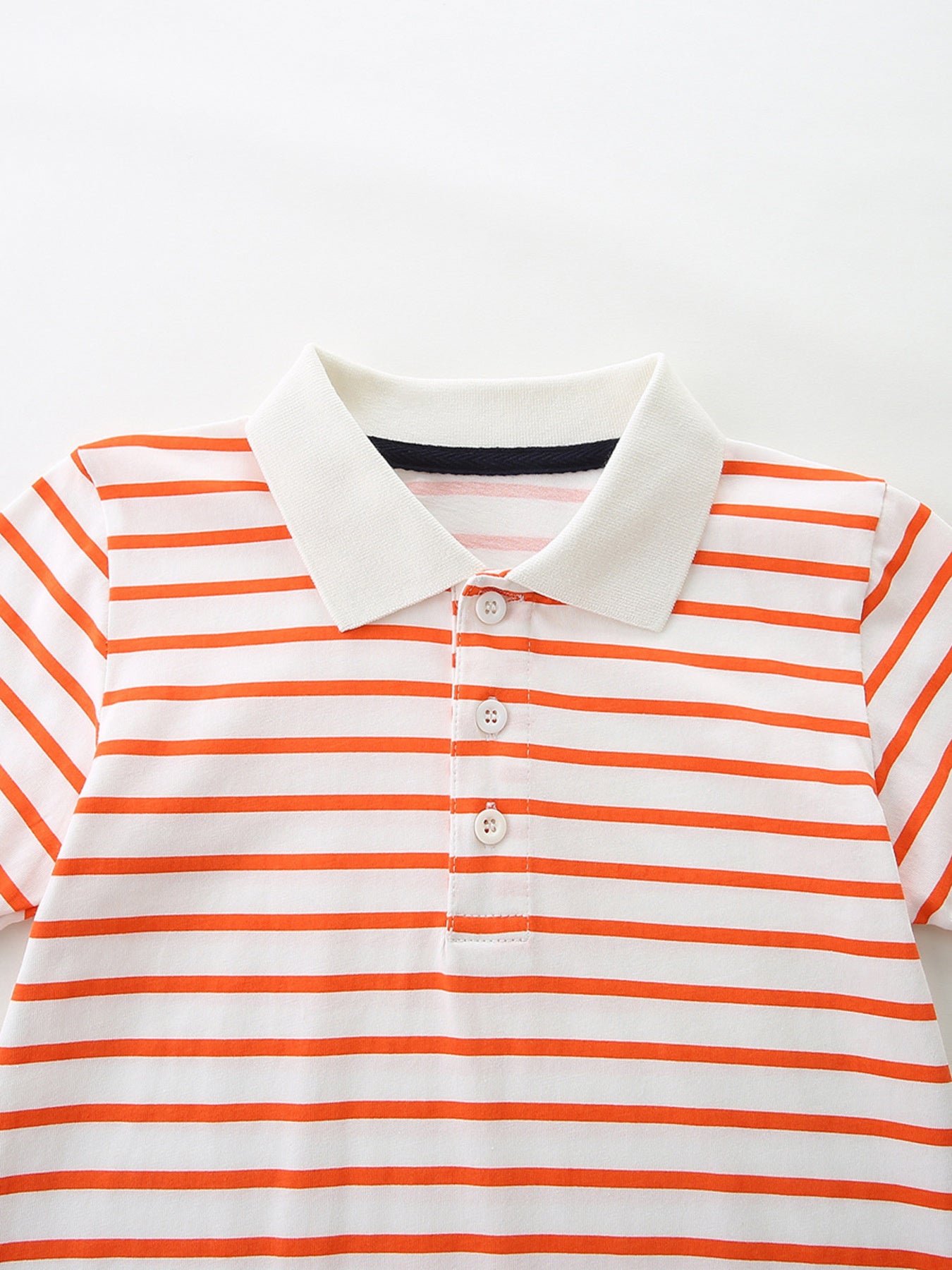 White and orange striped cotton polo shirt with button placket and white collar.