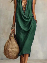 Dark green cowl neck midi dress with pockets and layered necklaces.