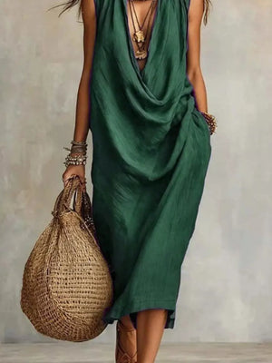 Dark green cowl neck midi dress with pockets and layered necklaces.
