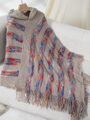 Textured knit hooded cape in tan with colorful diamond pattern and fringe.