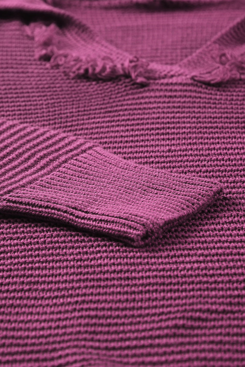 Burgundy textured knit pullover sweater with fringe trim and ribbed cuff detail.
