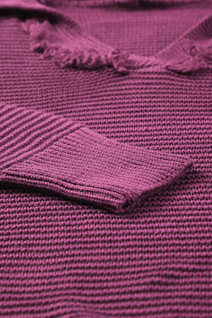 Burgundy textured knit pullover sweater with fringe trim and ribbed cuff detail.