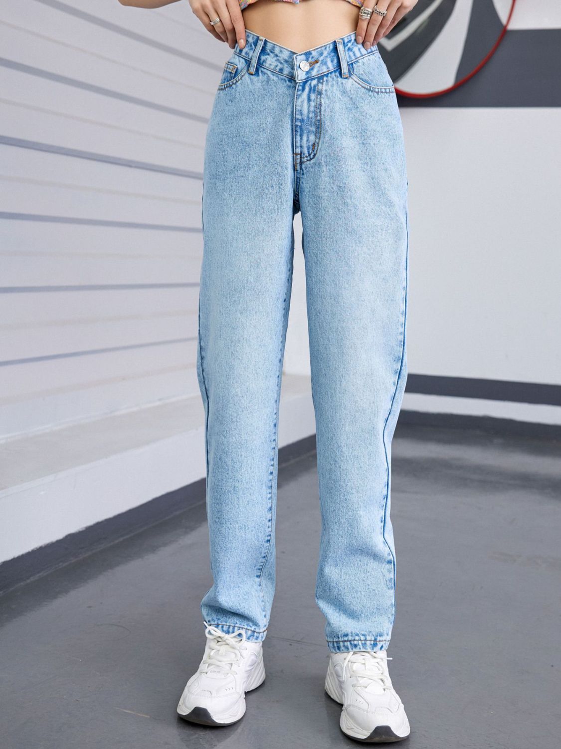 Light wash denim jeans with V-waistline and relaxed fit.