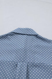 Blue polka dot polyester shirt with a collared neckline and subtle pleating detail.
